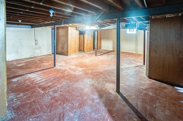 basement featuring wooden walls