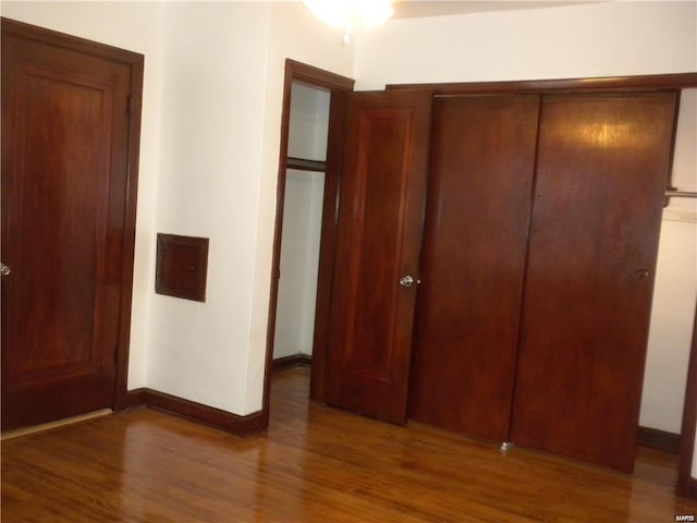 unfurnished bedroom featuring dark hardwood / wood-style flooring and a closet