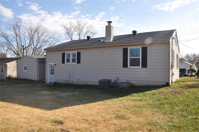 back of property featuring cooling unit and a lawn