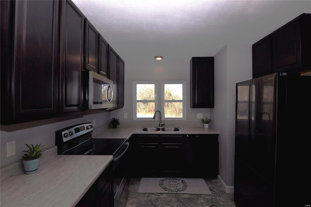 kitchen featuring sink, dark brown cabinets, stainless steel appliances, and a textured ceiling