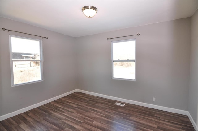 spare room with dark wood-type flooring