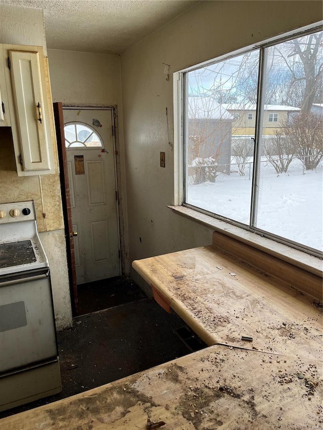 kitchen featuring plenty of natural light, a textured ceiling, and electric range oven