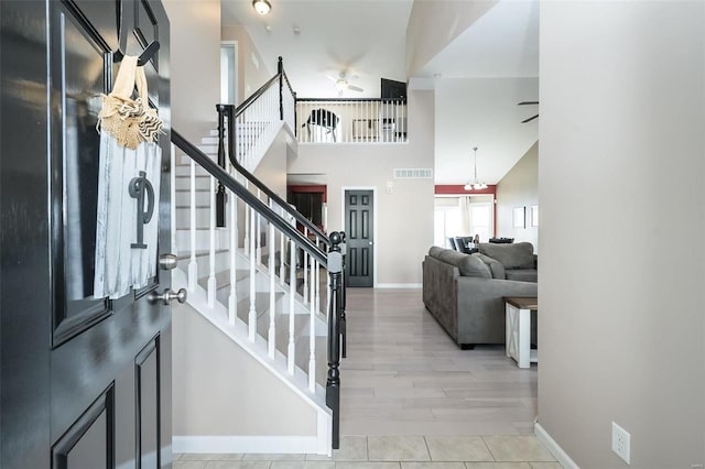 entrance foyer with ceiling fan and a high ceiling