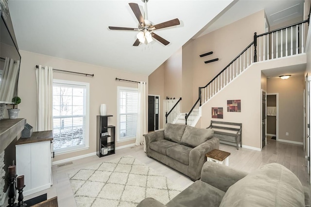 living room with ceiling fan, high vaulted ceiling, and light hardwood / wood-style flooring