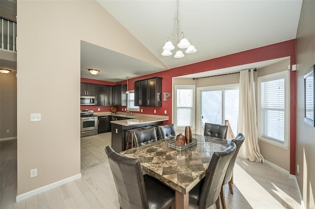 dining area featuring light hardwood / wood-style flooring, sink, a wealth of natural light, and vaulted ceiling