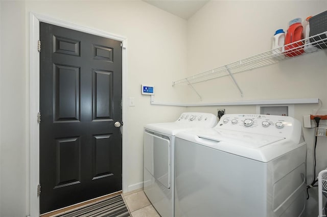 clothes washing area featuring washing machine and clothes dryer and light tile patterned flooring