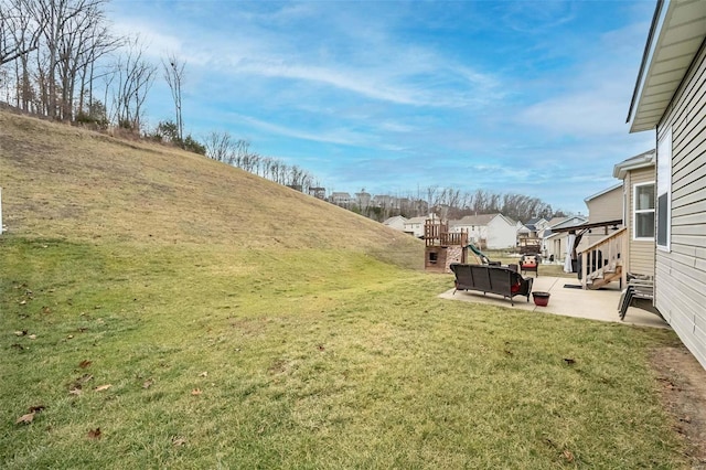 view of yard featuring a playground and a patio area