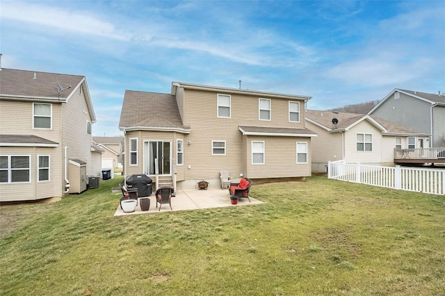 rear view of house with a yard, central AC, and a patio area