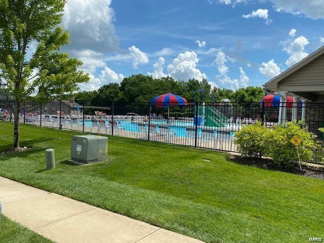 view of pool with a lawn