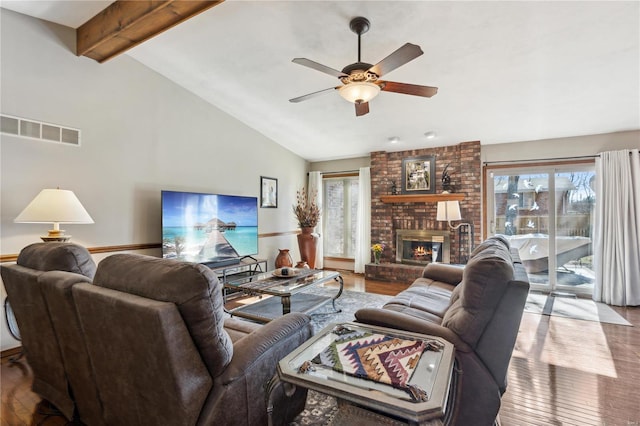 living room featuring hardwood / wood-style flooring, vaulted ceiling with beams, and a wealth of natural light