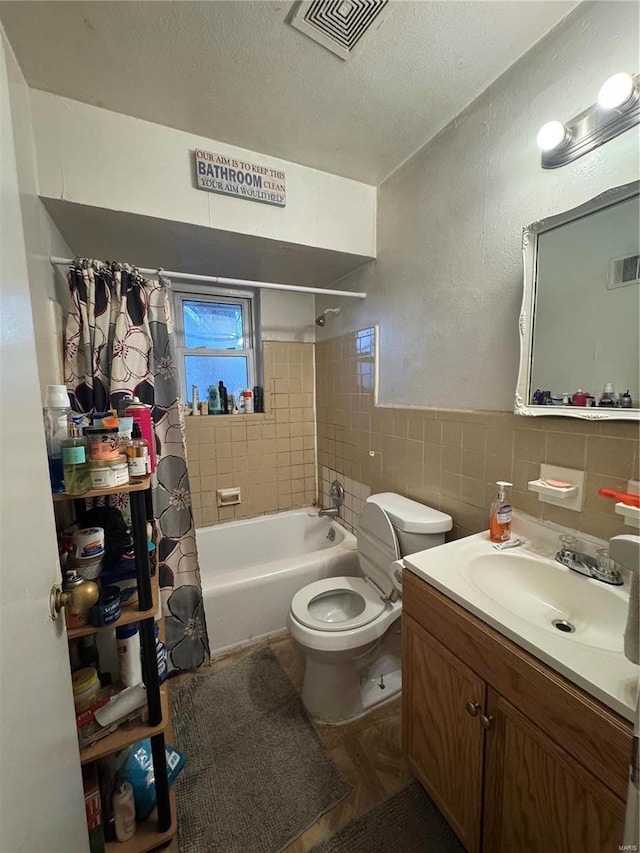 full bathroom featuring a textured ceiling, vanity, shower / tub combo, tile walls, and toilet