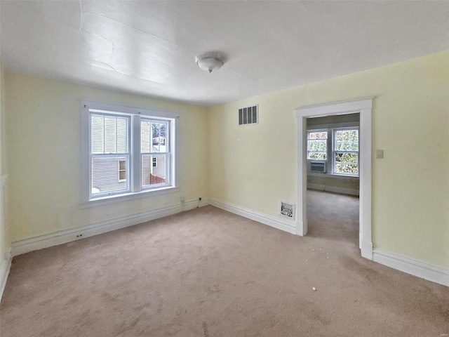 unfurnished room featuring light carpet