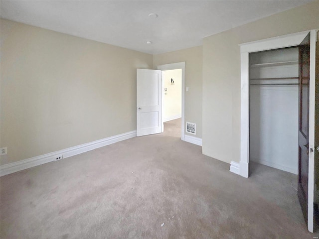 unfurnished bedroom with carpet flooring and a closet