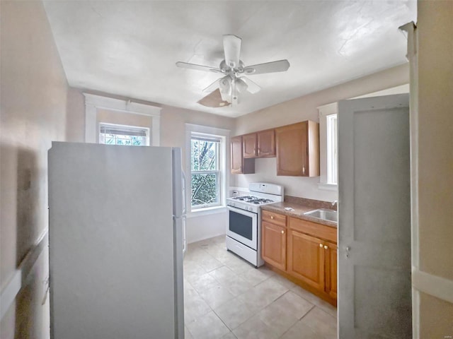 kitchen with ceiling fan, white appliances, sink, and light tile patterned floors