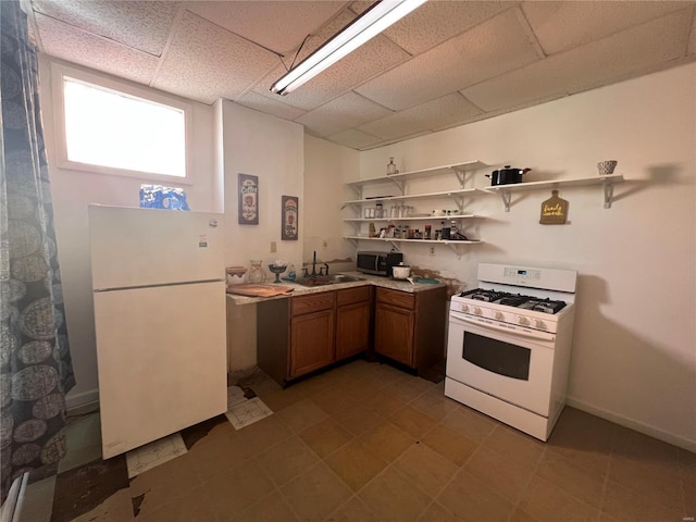 kitchen with white appliances, sink, and a paneled ceiling