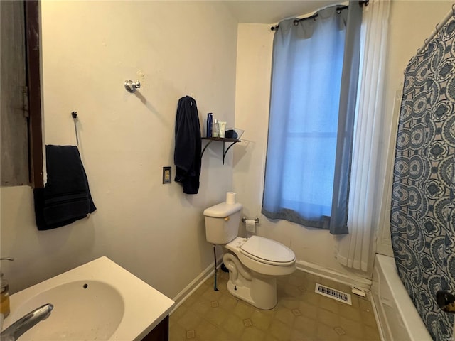 full bathroom with shower / tub combo with curtain, vanity, and toilet