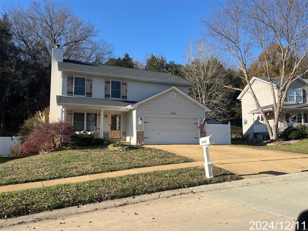 view of property with a front lawn and a garage