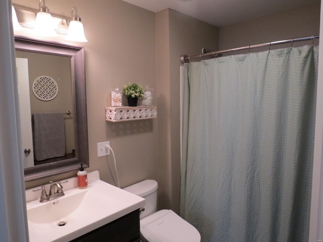 bathroom with vanity, curtained shower, and toilet