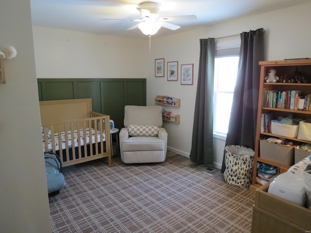 bedroom featuring a crib and ceiling fan