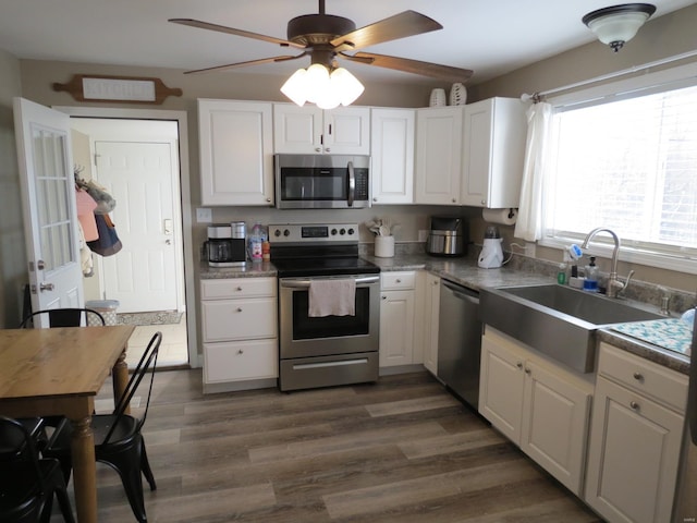 kitchen featuring white cabinetry, sink, dark hardwood / wood-style flooring, ceiling fan, and stainless steel appliances