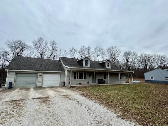 view of front of house featuring a porch, a garage, and a front yard