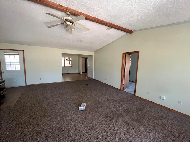 unfurnished living room with a textured ceiling, ceiling fan, vaulted ceiling with beams, and carpet flooring