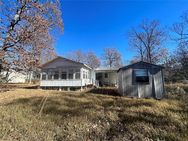 rear view of property featuring a sunroom