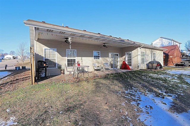 rear view of property featuring ceiling fan and a patio area