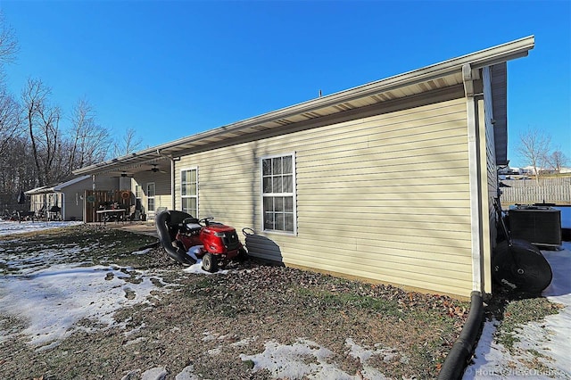 view of snow covered exterior featuring ceiling fan and central AC