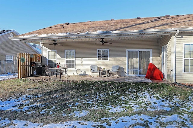 snow covered back of property featuring ceiling fan and a patio area