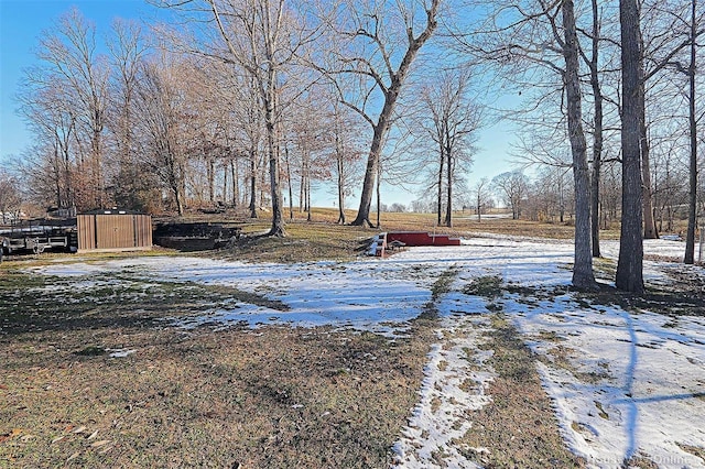 yard layered in snow featuring a storage shed