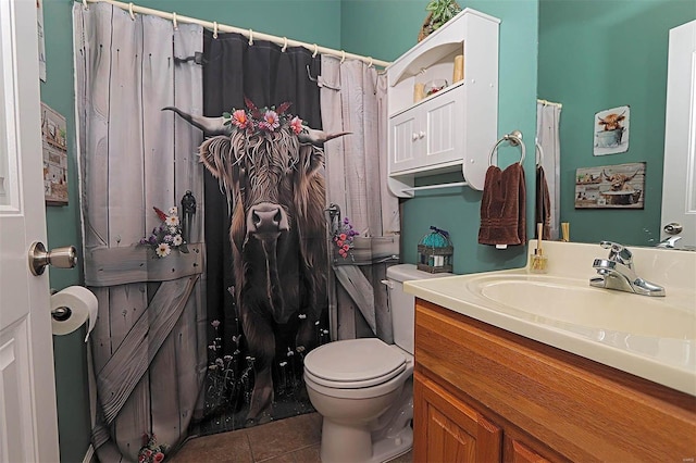 bathroom with toilet, vanity, and tile patterned floors