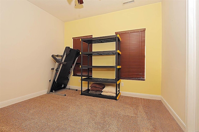 exercise room with ceiling fan and carpet