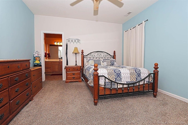 carpeted bedroom with ensuite bathroom and ceiling fan