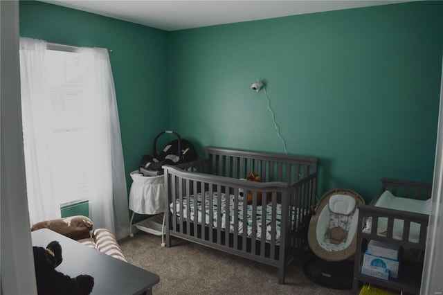 bedroom featuring a crib and carpet