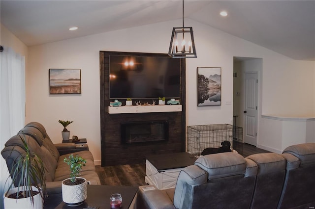 living room with a large fireplace, a notable chandelier, dark hardwood / wood-style flooring, and lofted ceiling