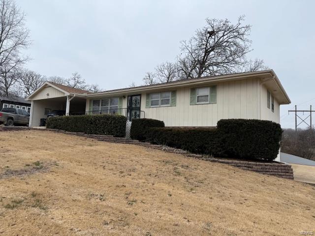 ranch-style home featuring a carport