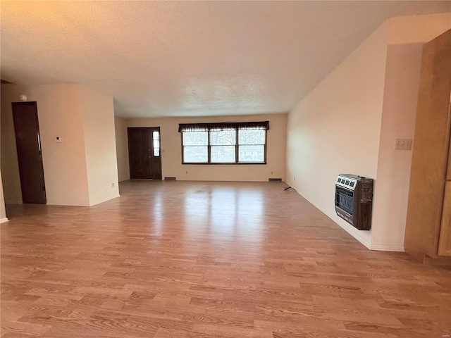 unfurnished living room with a textured ceiling, heating unit, and light wood-type flooring