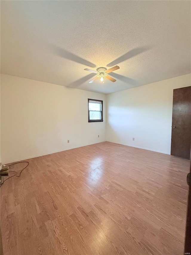 spare room with ceiling fan, a textured ceiling, and light wood-type flooring