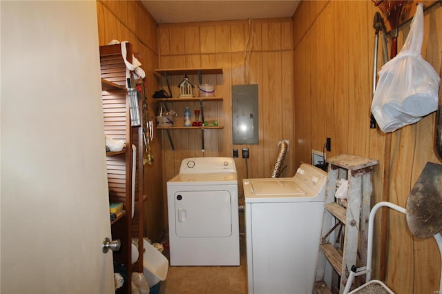 washroom featuring separate washer and dryer, wooden walls, and electric panel