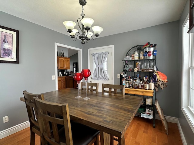 dining room with wood-type flooring and an inviting chandelier