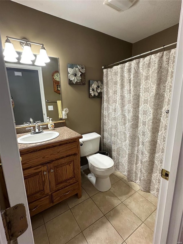 bathroom with tile patterned flooring, vanity, and toilet