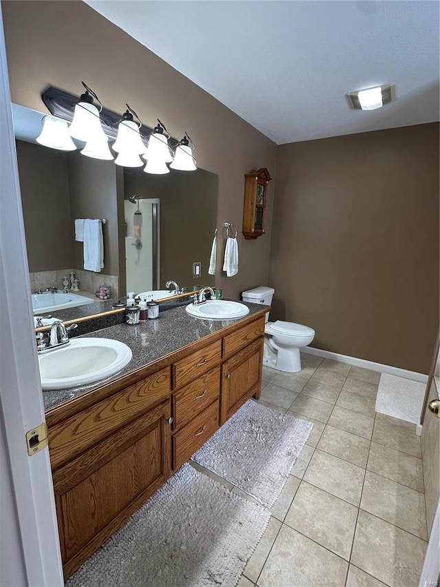 bathroom featuring a tub to relax in, tile patterned flooring, vanity, and toilet