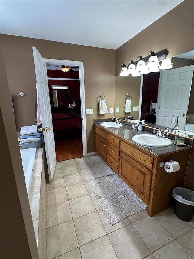 bathroom with tile patterned flooring, vanity, ceiling fan, and a tub to relax in