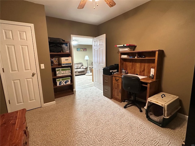 carpeted office space featuring ceiling fan