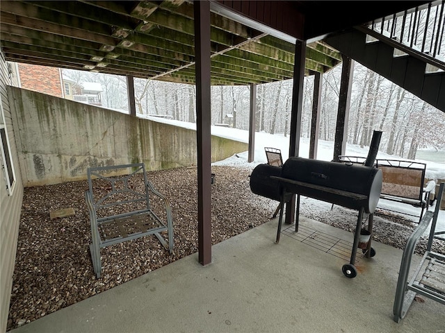 snow covered patio with a grill