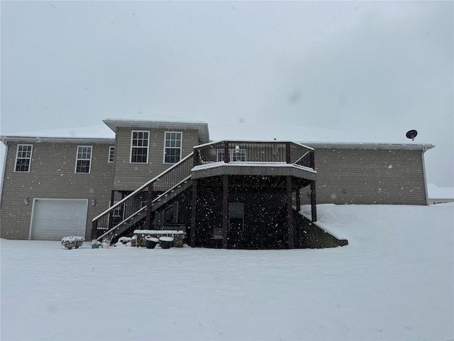 snow covered property with a garage