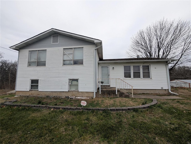 rear view of property with a lawn