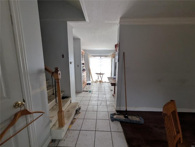 corridor with crown molding and light tile patterned floors