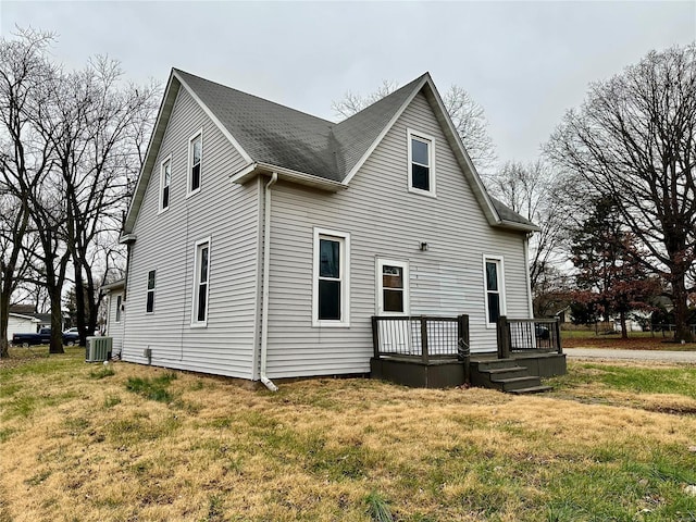 back of property with central air condition unit, a wooden deck, and a yard